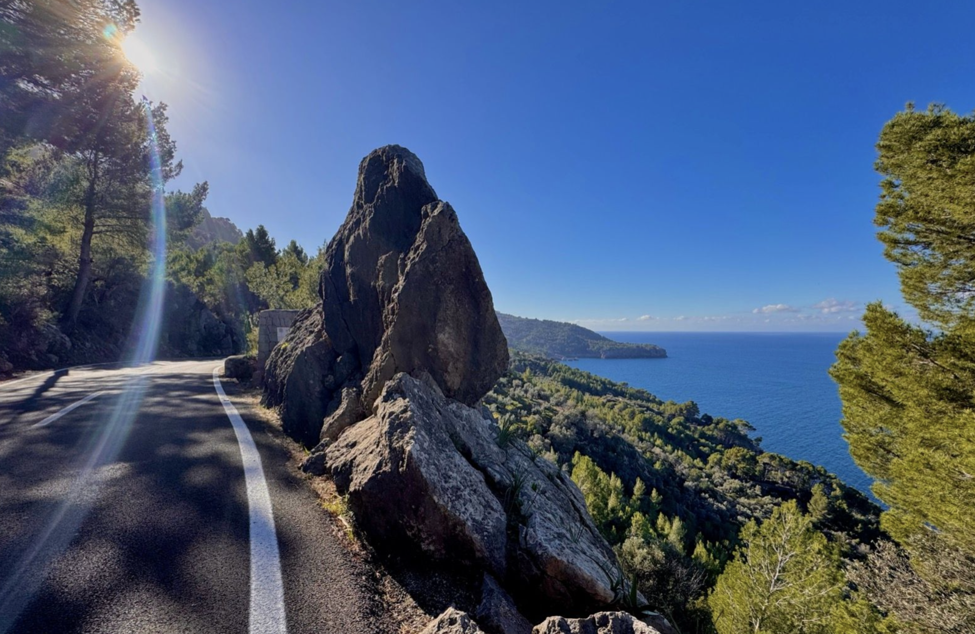 Cyclist on the coastal road above Banyalbufar's terraced hillsides on Mallorca's west coast